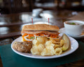 Plated sandwich with sides on a table in a casual setting