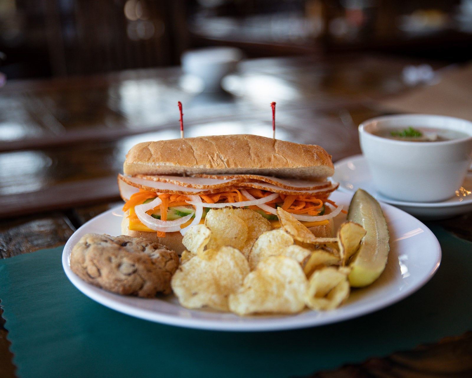 Plated sandwich with sides on a table in a casual setting