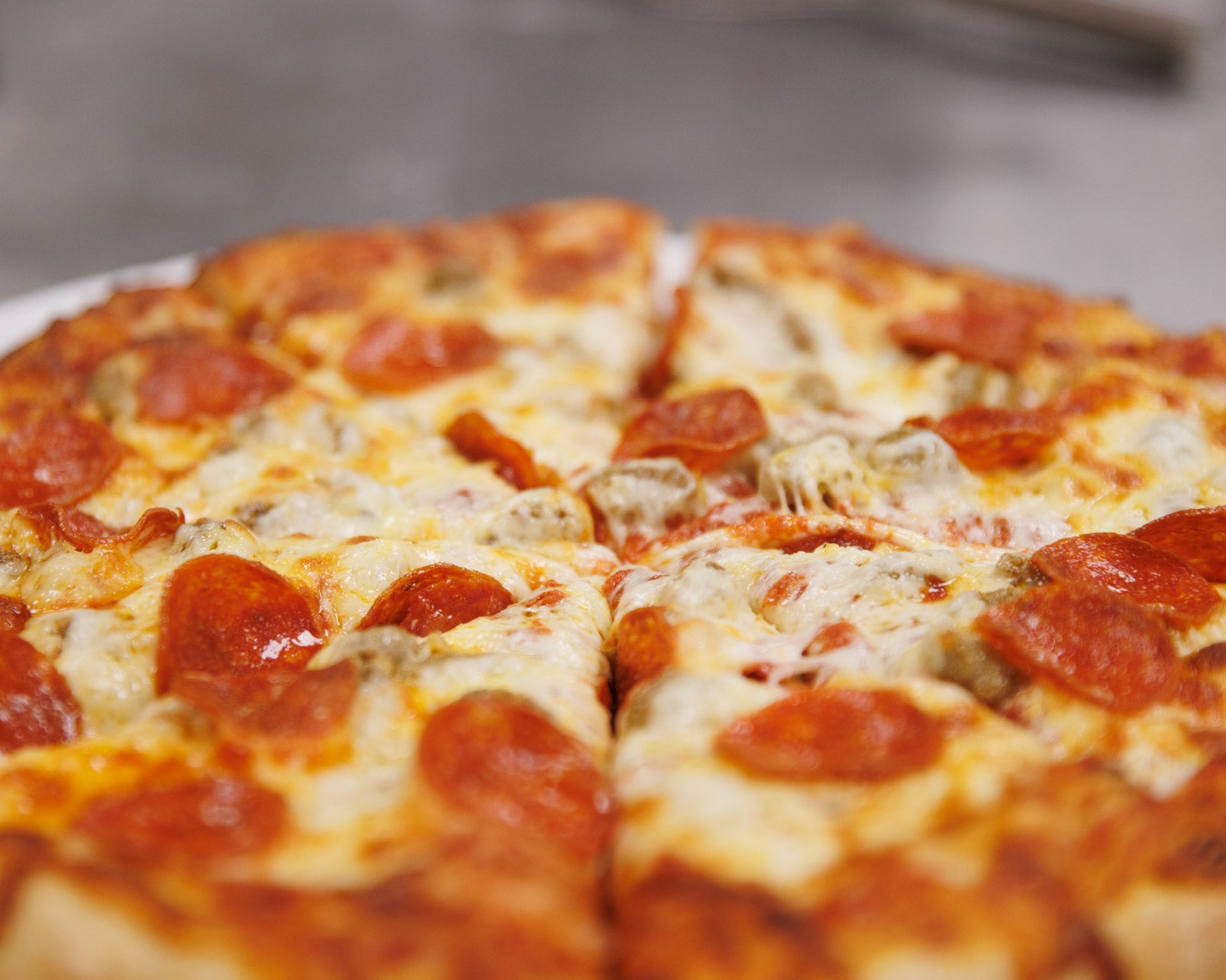 Sausage and pepperoni pizza with a blurred background